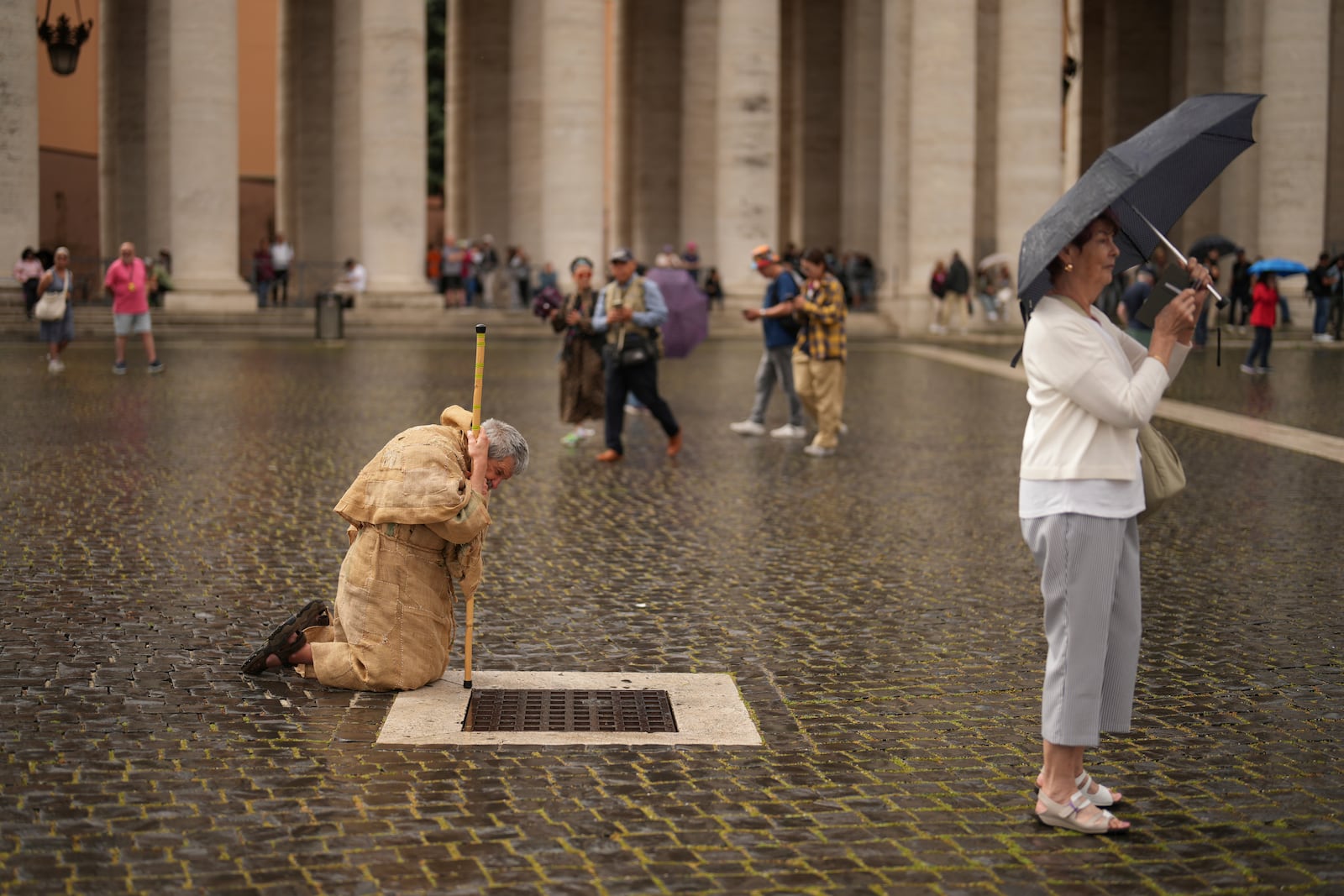 A faithful prays in St. Peter's Square during a final Mass by cardinals ahead of the conclave, at the Vatican, Wednesday, May 7, 2025. (AP Photo/Francisco Seco)