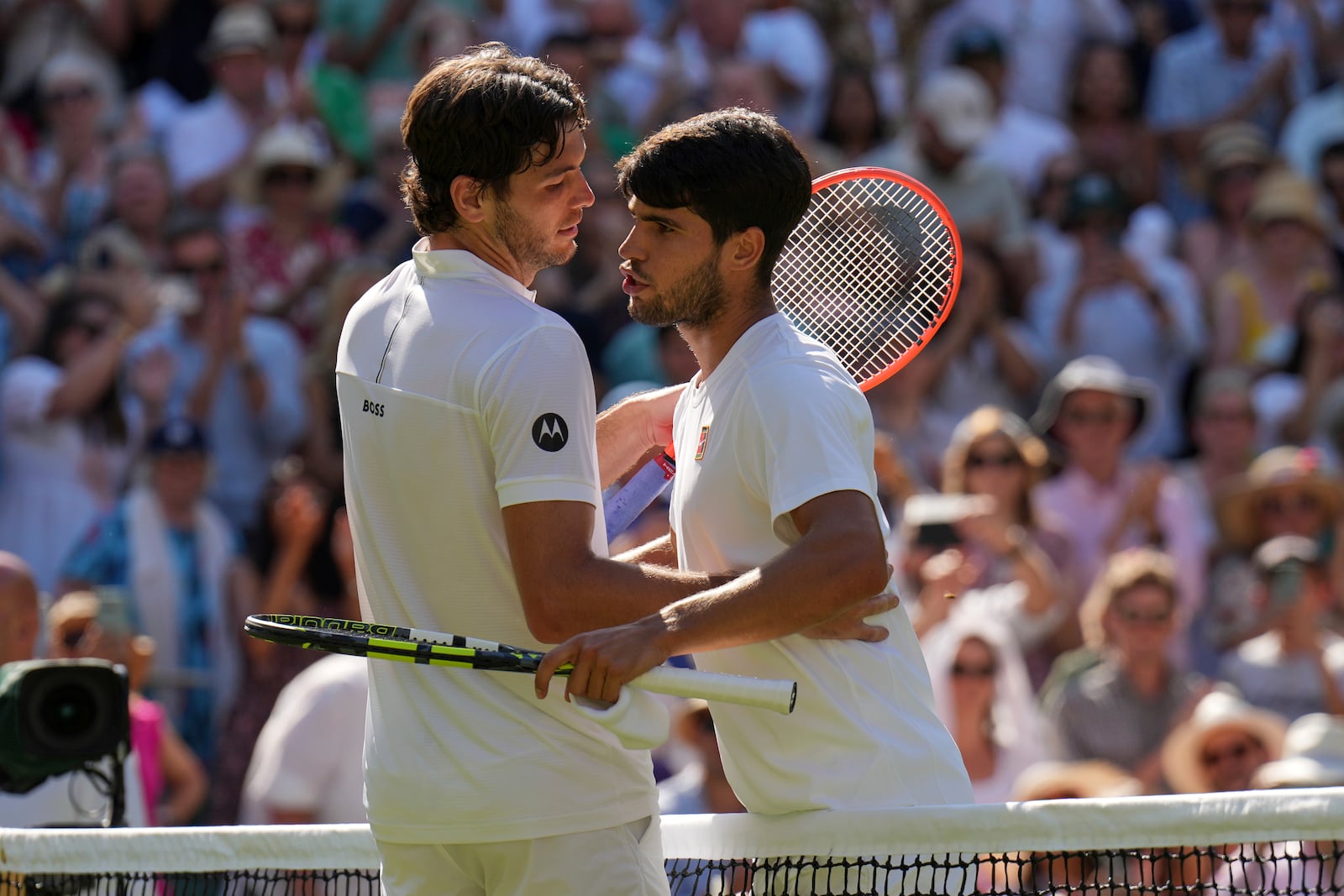 Spain's Carlos Alcaraz, right, greets Taylor Fritz of the U.S. after beating him in a men's singles semifinal at the Wimbledon Tennis Championships in London, Friday, July 11, 2025. (AP Photo/Kin Cheung)