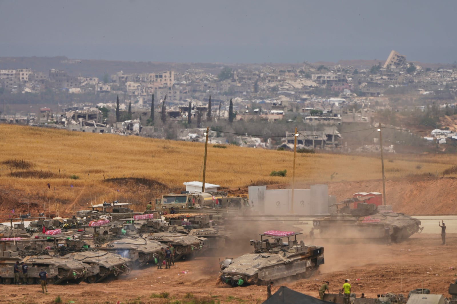 Israeli soldiers work on tanks and APCs at a staging area near the border with the Gaza Strip, in southern Israel, Thursday, May 15, 2025. (AP Photo/Ariel Schalit)