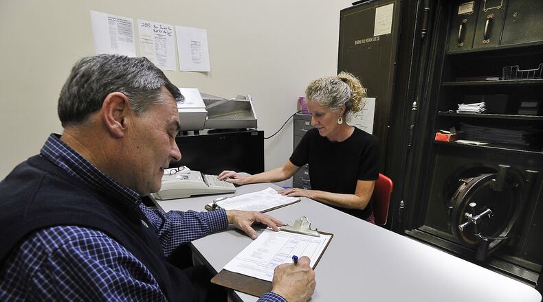 Clark County Treasurer Stephen Metzger, and treasurer employee Denise Garrett sit in a large safe as they work on a daily budget at the Treasurer’s office Monday. Staff photo by Bill Lackey