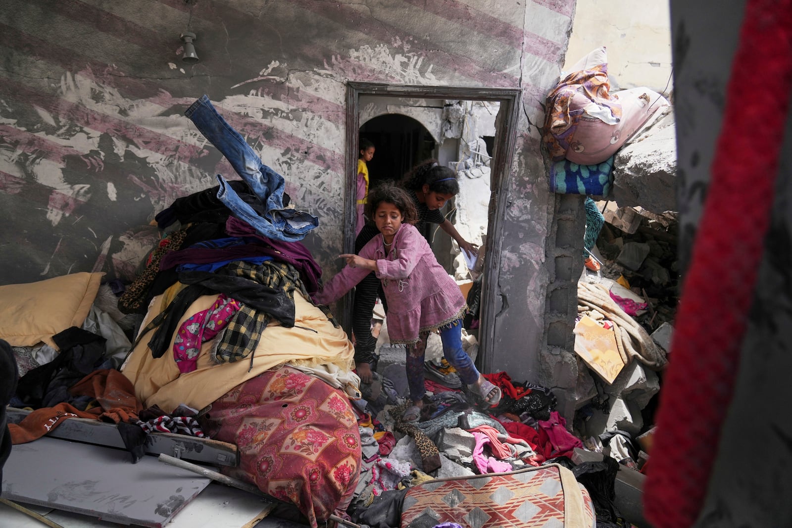 Palestinians children look for good to recover in a house damaged by an Israeli army strike that killed at least five people in Khan Younis, in the southern Gaza Strip, on Thursday, May 1, 2025. (AP Photo/Abdel Kareem Hana)