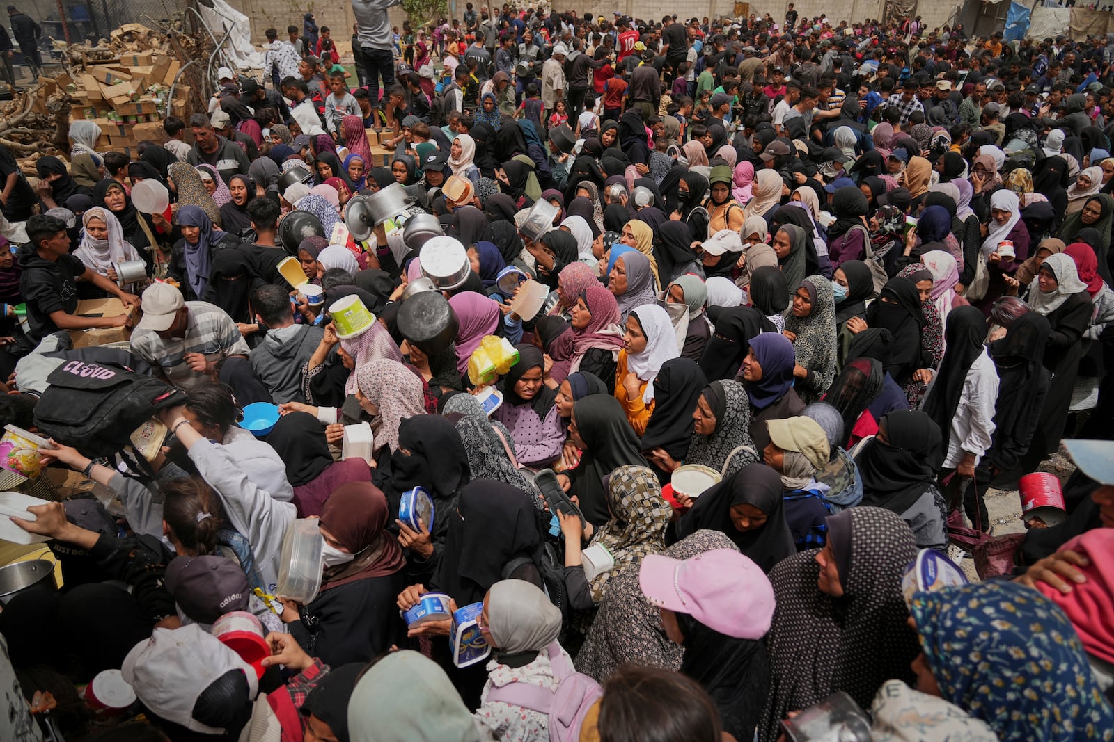 Palestinians struggle in a crowd as they try to receive donated food at a distribution center in Nuseirat, central Gaza Strip, Wednesday, April 30, 2025. (AP Photo/Abdel Kareem Hana)