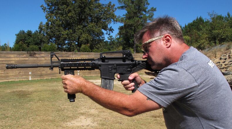 Shooting instructor Frankie McRae aims an AR-15 rifle fitted with a “bump stock” at his 37 PSR Gun Club in Bunnlevel, N.C., on Wednesday, Oct. 4, 2017. The stock uses the recoil of the semiautomatic rifle to let the finger “bump” the trigger, making it different from a fully automatic machine gun, which are illegal for most civilians to own. (AP Photo/Allen G. Breed)