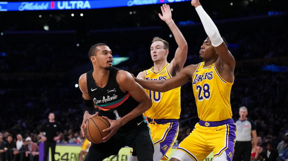 San Antonio Spurs forward Victor Wembanyama (1) is double-teamed by Los Angeles Lakers forward Rui Hachimura (28) and guard Luke Kennard (10) during the first half of an NBA basketball game Tuesday, Feb. 10, 2026, in Los Angeles. (AP Photo/Jae C. Hong)