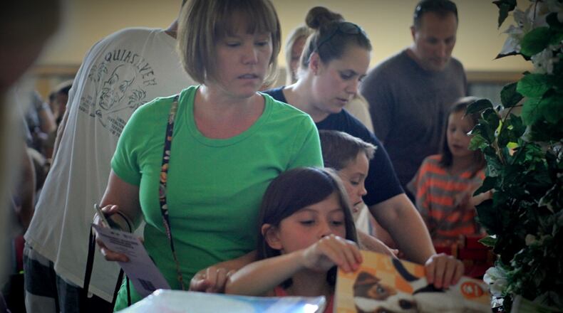 Sherry Metcalf and daughter Bella Metcalf, of Columbus, pick out school supplies donated from the Operation Homefront Back-to-School Brigade on Wednesday, Aug. 3, 2016, at the Hotel Dayton in Harrison Twp. (Jim Noelker/Staff)