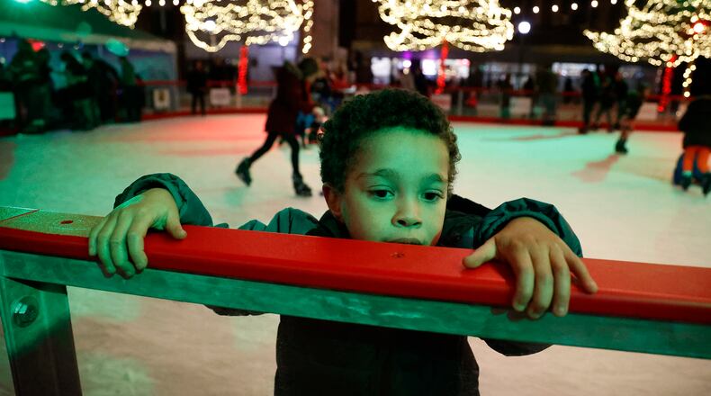 Noah Campbell works his way along the wall of the outdoor ice skating rink on the Springfield City Hall Plaza as he tries ice skatting for the first time Friday, Nov. 25, 2022. BILL LACKEY