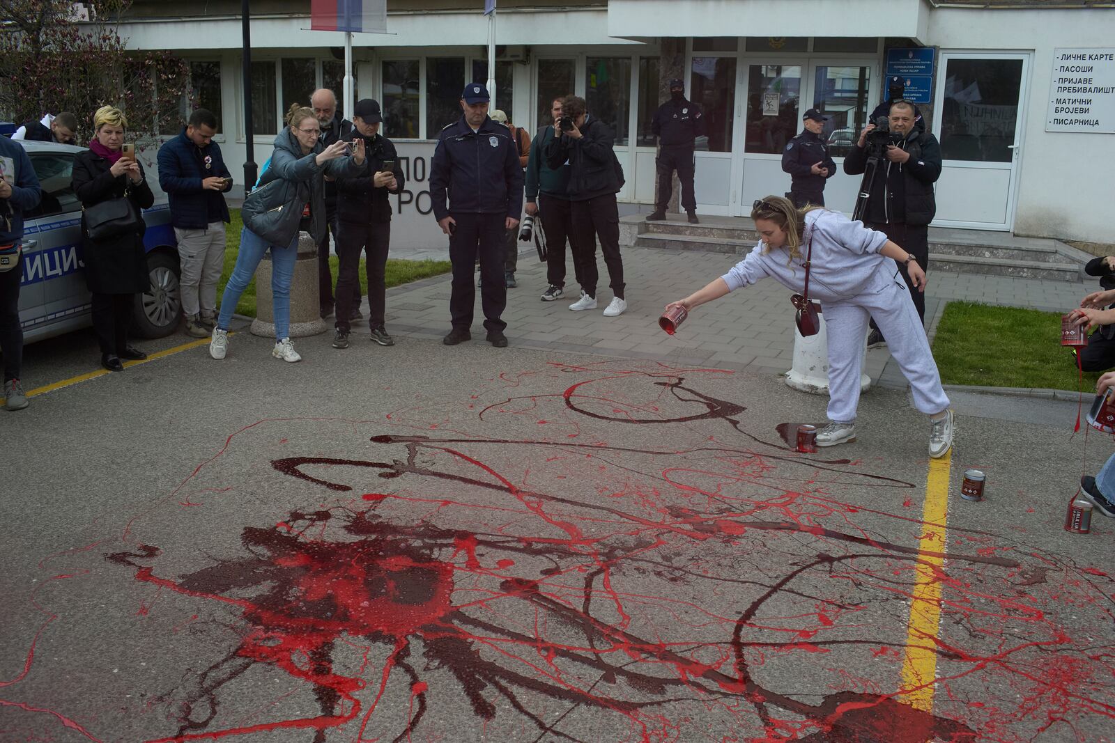 Protesters spill red paint in front of a local police station during an anti-corruption protest led by university students in the southwestern town of Novi Pazar, Serbia, Saturday, April 12, 2025. (AP Photo/Marko Drobnjakovic)