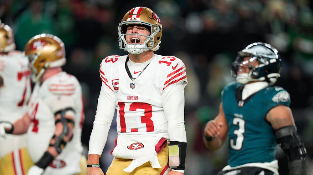 San Francisco 49ers quarterback Brock Purdy (13) reacts to a touchdown pass to 49ers running back Christian McCaffrey during the second half of an NFL wild-card playoff football game against the Philadelphia Eagles on Sunday, Jan. 11, 2026, in Philadelphia. (AP Photo/Chris Szagola)