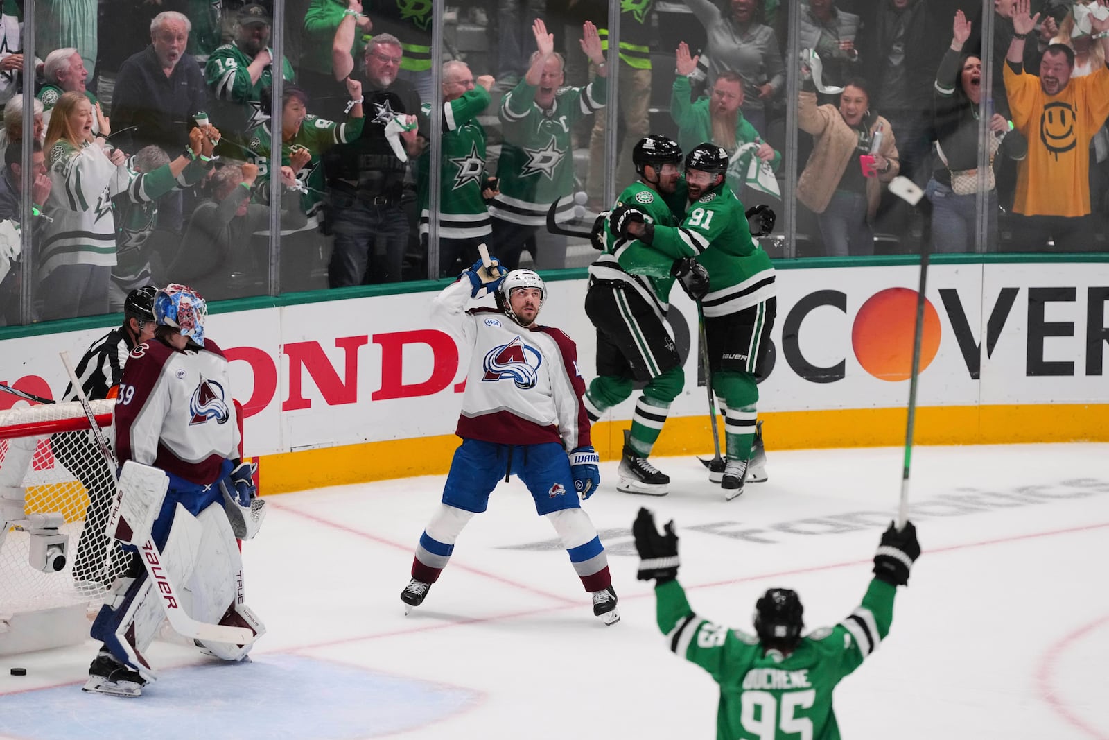 Colorado Avalanche goaltender Mackenzie Blackwood (39) and Samuel Girard, center, look on as the Dallas Stars celebrate a goal scored by Dallas Stars' Mikko Rantanen, rear, in the third period in Game 7 of a first-round NHL hockey playoff series Saturday, May 3, 2025, in Dallas. (AP Photo/Julio Cortez)