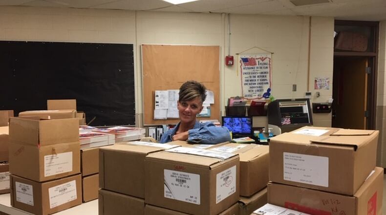 Leslie Renner, secretary in the Enon Primary office works behind boxes of school supplies as she preparees for the start of school. PAM COTTREL/CONTRIBUTED
