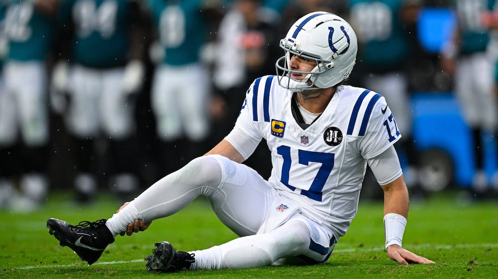Indianapolis Colts quarterback Daniel Jones (17) grabs his leg after an injury during the first half of an NFL football game against the Jacksonville Jaguars, Sunday, Dec. 7, 2025, in Jacksonville, Fla. (AP Photo/Phelan M. Ebenhack)