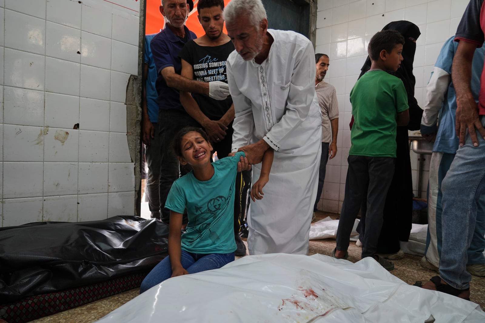 Palestinian girl Rafeef Abu Ghaly mourns the loss of her grandparents, who were killed in an Israeli airstrike on Al-Zawaideh, at Al-Aqsa Hospital morgue in Deir al-Balah, Gaza Strip, on Tuesday, July 1, 2025. (AP Photo/Abdel Kareem Hana)