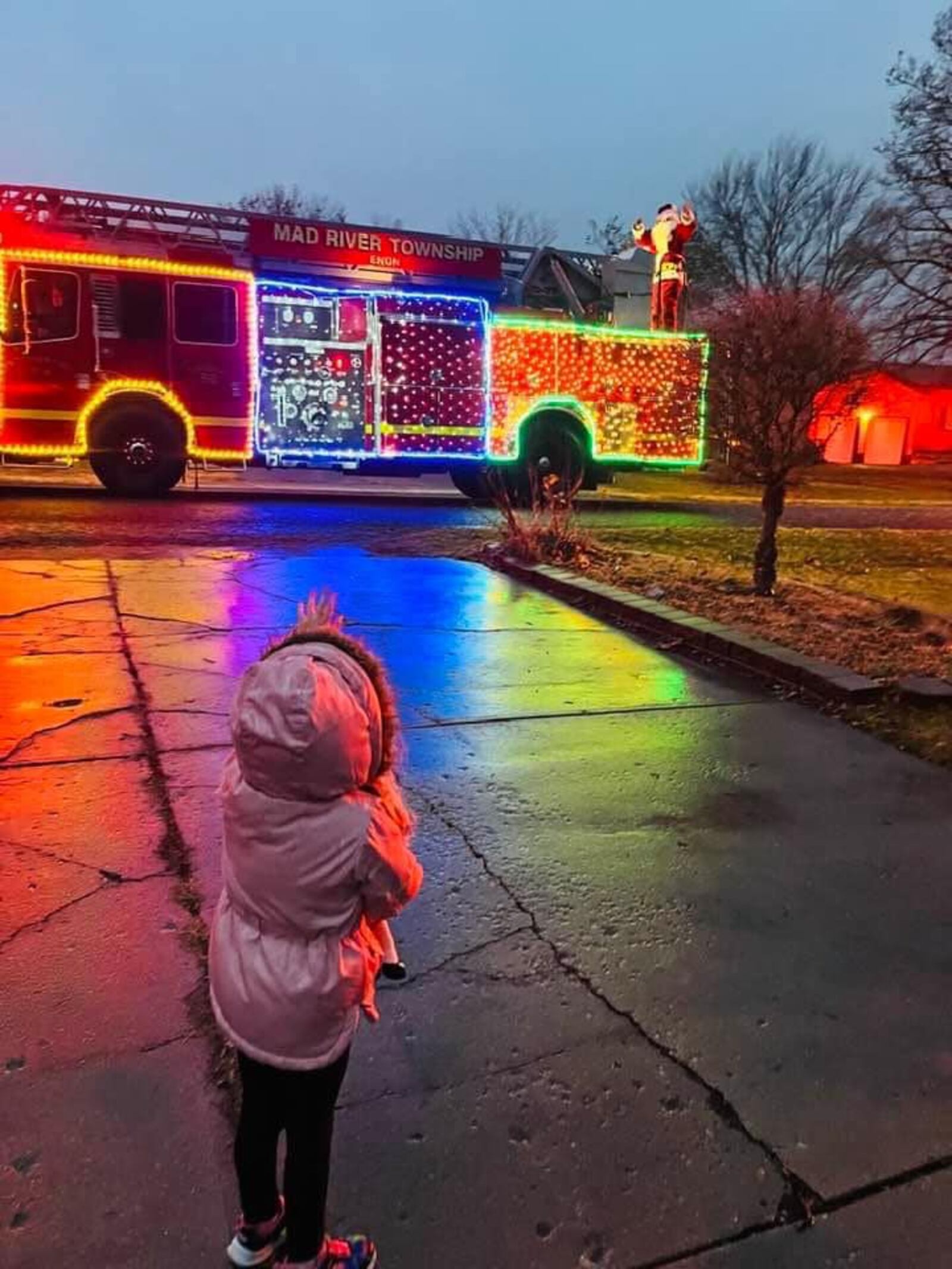 Four year old Remi Palmer waves at Santa who is riding on a highly decorated Ladder 50. CONTRIBUTED