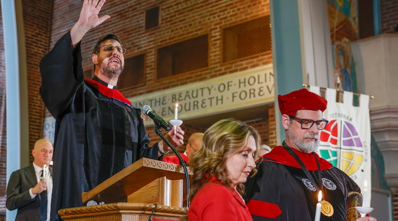 Rev. Dr. Scott Ness gives a benediction in front of Dr. Christian M.M. Brady and his wife Elizabeth Brady on Friday, October 17, 2025, at Wittenberg University's Weaver Chapel. Dr. Brady was inaugurated as president today. JOSEPH COOKE/STAFF