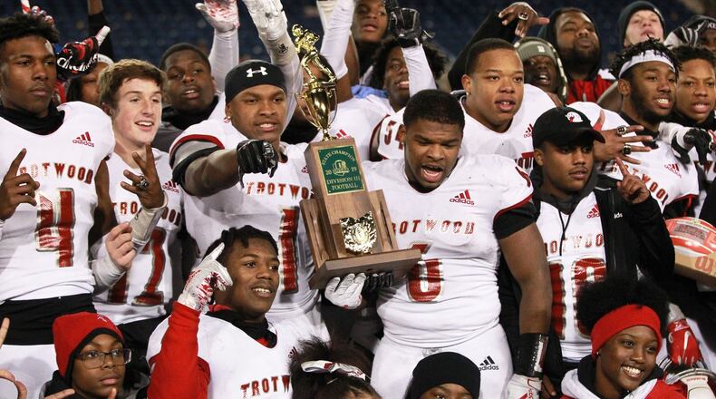 Trotwood-Madison twin brothers Keon’tae (left) and Ke’Shawn Huguely (both holding trophy) celebrate with teammates. Trotwood defeated Mansfield Senior 14-7 in overtime to win the Division III high school football championship at Tom Benson Hall of Fame Stadium in Canton on Friday. It was the Rams’ (12-3) third football state title, along with its 2011 and ‘17 championship teams. Anna also won a D-VI title on Friday and Marion Local will bid for the D-VII state title on Saturday. MARC PENDLETON / STAFF