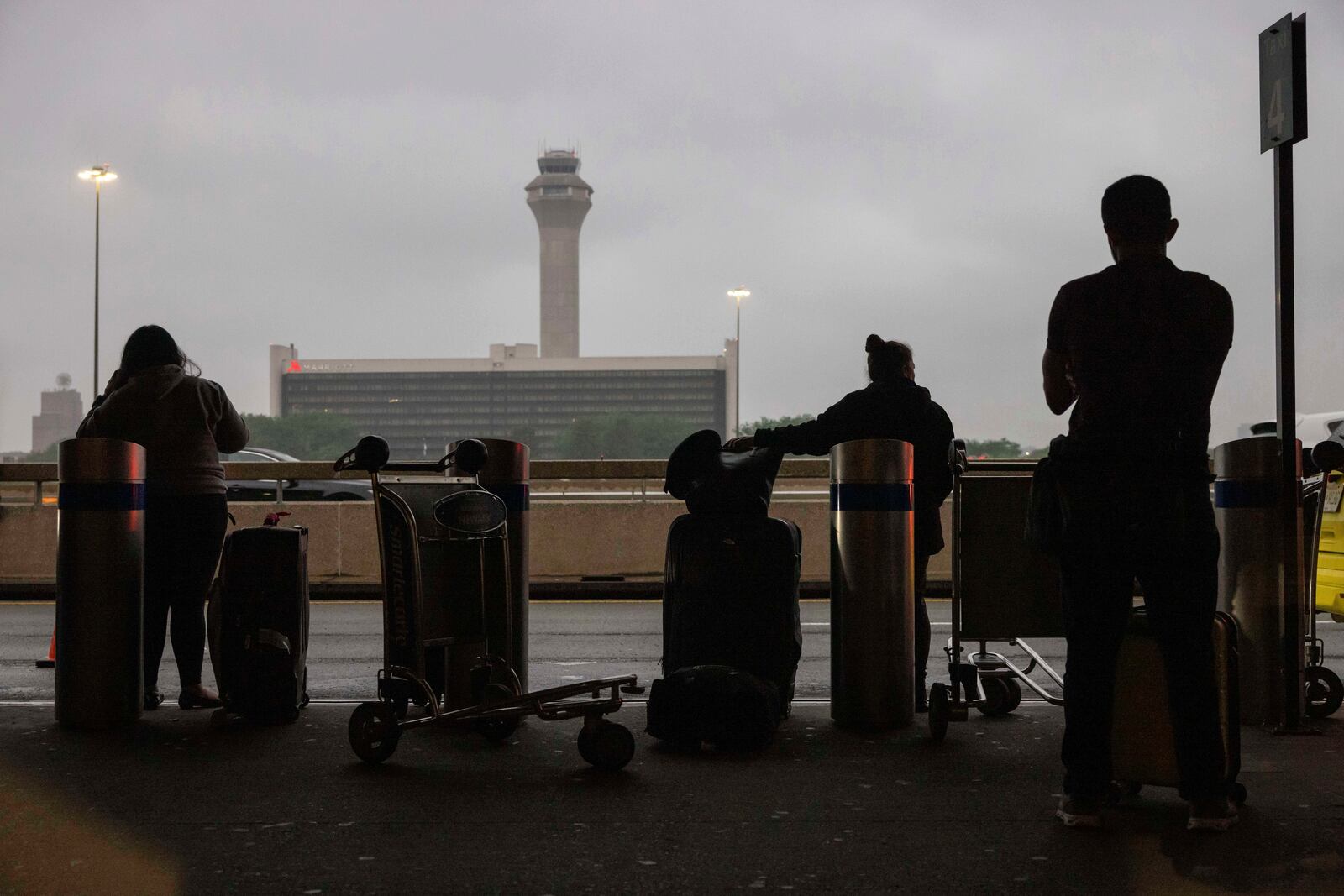 People wait for a taxi at the international terminal at Newark Liberty International Airport, Monday, June 9, 2025, in New Jersey. (AP Photo/Yuki Iwamura)