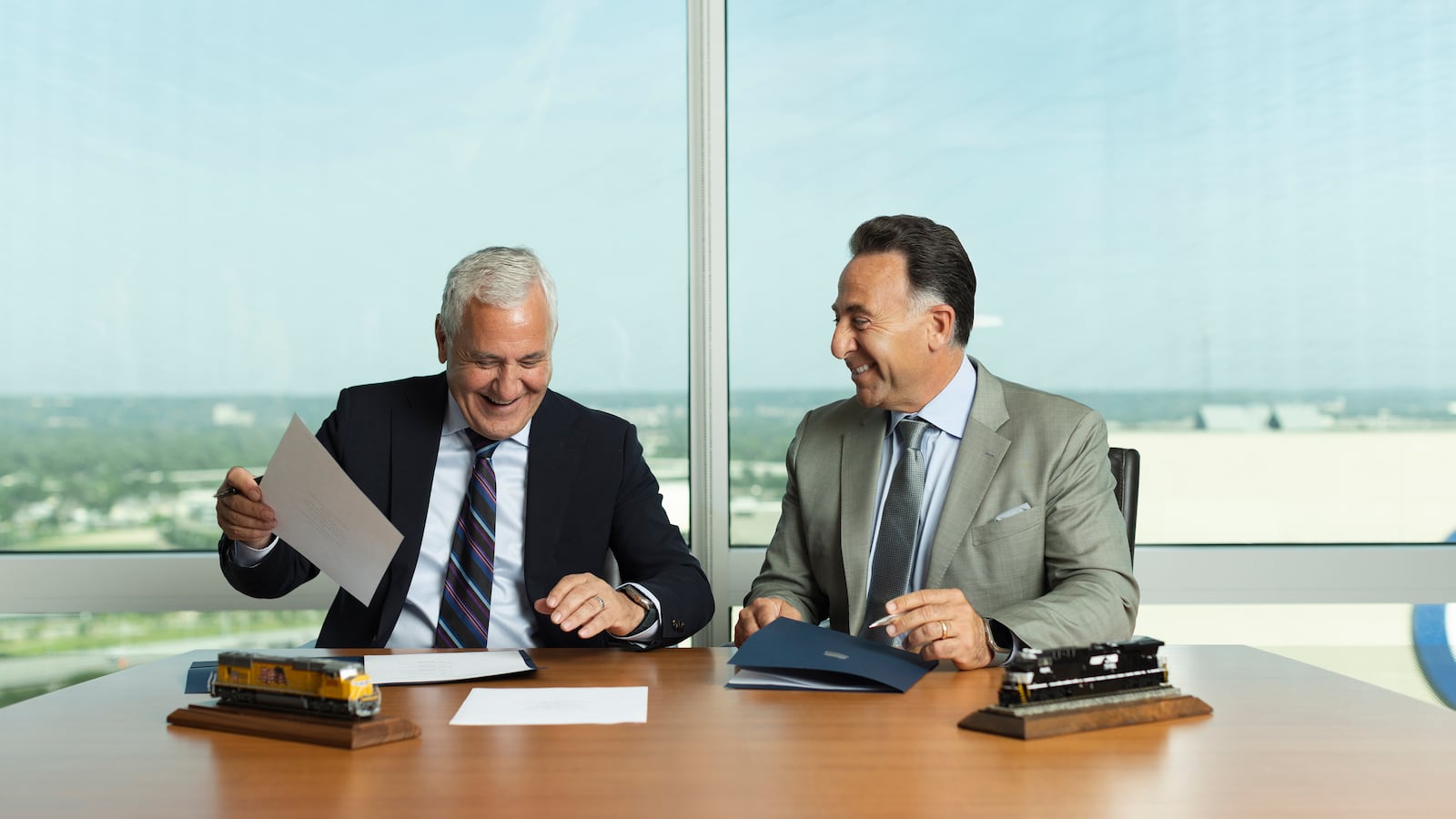In this photo provided by Union Pacific, from left, Union Pacific CEO Jim Vena sits next to Norfolk Southern CEO Mark George as both men sign the agreement to merge the two railroads they lead on Monday, July 28, 2025 in Omaha, Neb. (Bill Sitzmann/Union Pacific via AP)