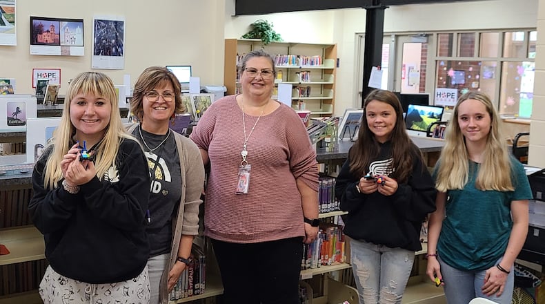 Tecumseh Middle School offers a "Career Cafe" for student to look at different Springfield-Clark Career Technology programs each month during study hall. In this photo is Kathy Oaster (middle) with Melinda Scaggs (second from left) and students with the Lego cars they made for the automotive unit. Contributed