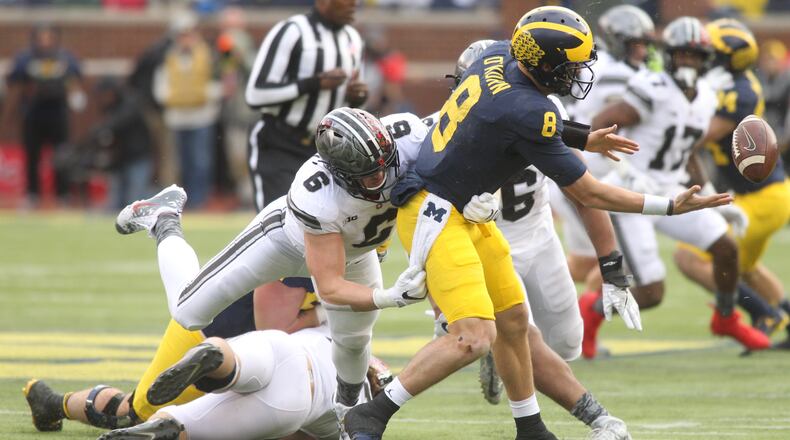 Ohio State’s Sam Hubbard forces a fumble against Michigan’s John O’Korn on Saturday, Nov. 25, 2017, at Michigan Stadium in Ann Arbor, Mich. David Jablonski/Staff