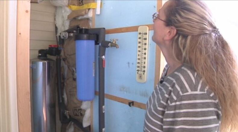 Donnelsville resident Tracy Griffin examines her water filtration system. Griffin is one of the 20 percent of residents with contaminated water. JENNA LAWSON/STAFF
