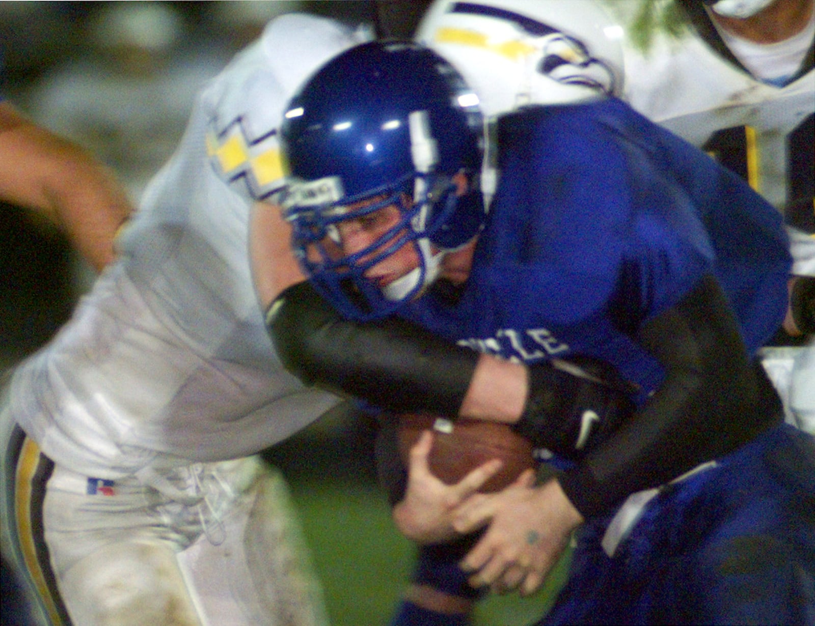 Brookville's Randy Hubley gets wrapped up by Eaton defender during first quarter run play by the Blue Devils. DAMON HIGGINS / FILE PHOTO
