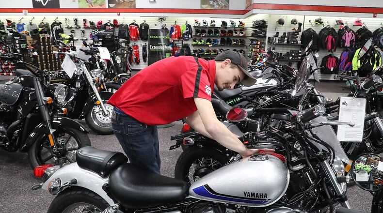 Reese Shafer polishes a motorcycle in the showroom at Ride 1 Powersports on Leffel Lane Wednesday. BILL LACKEY/STAFF