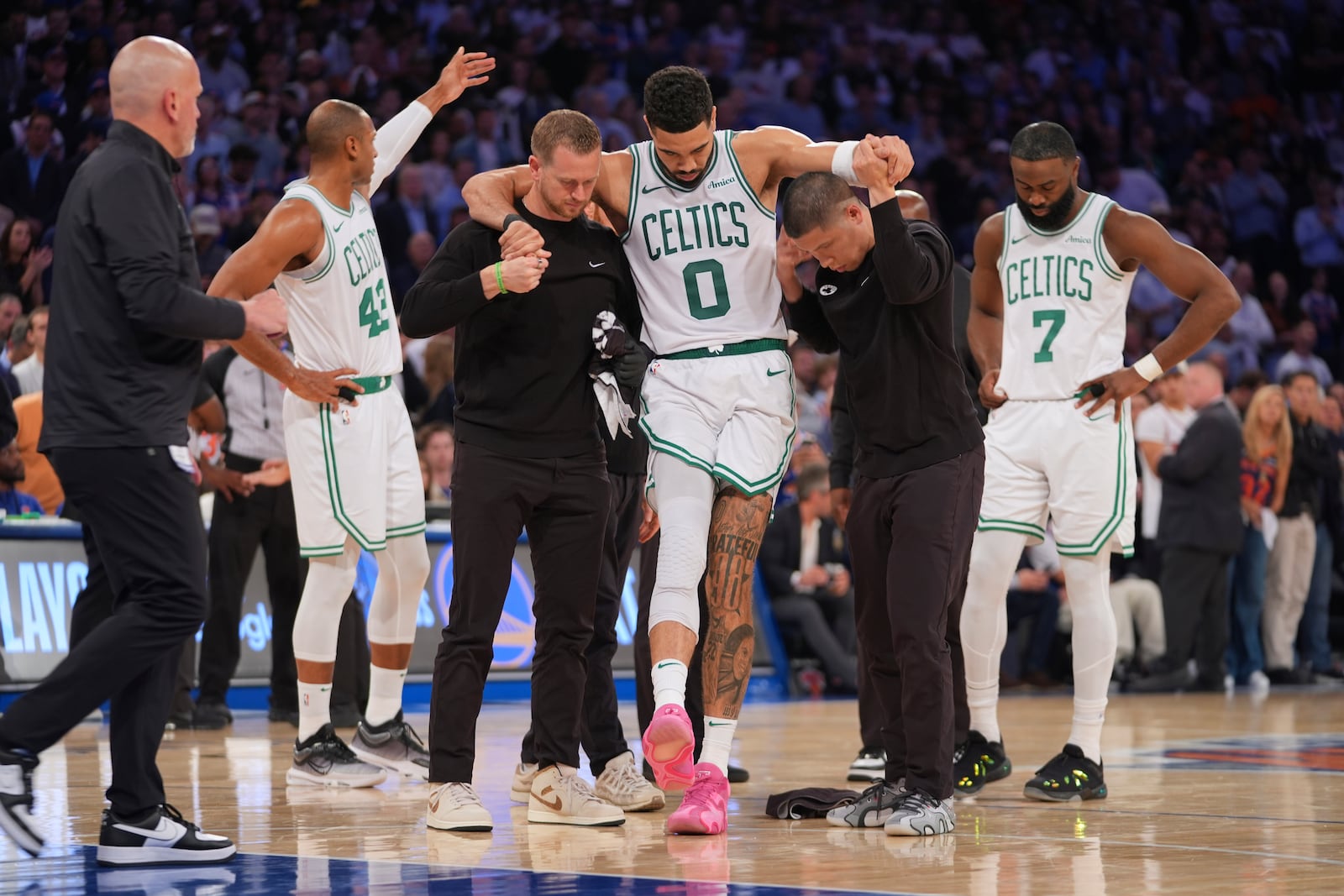 Trainers help Boston Celtics' Jayson Tatum (0) off the court after he was injured during the second half of Game 4 in the Eastern Conference semifinals of the NBA basketball playoffs against the New York Knicks Monday, May 12, 2025, in New York. (AP Photo/Frank Franklin II)