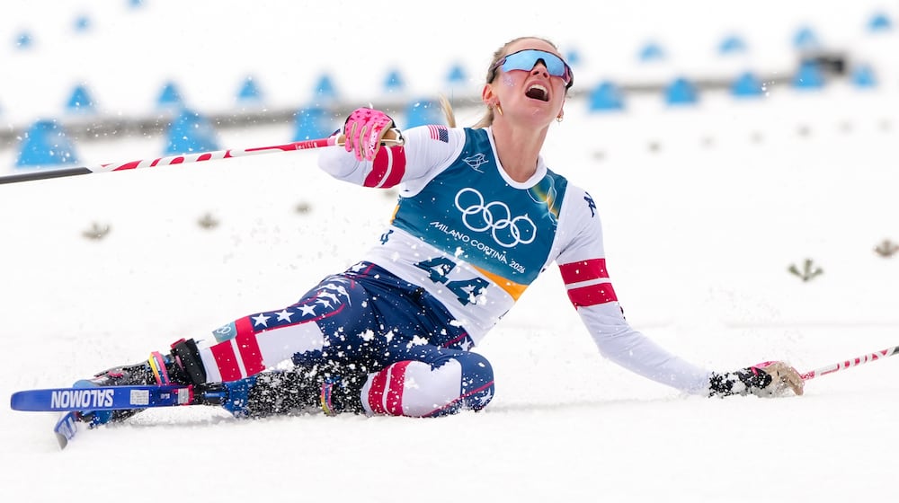 Jessie Diggins, of the United States, falls to the ground after crossing the finish line in the cross country skiing women's 10km interval start free at the 2026 Winter Olympics, in Tesero, Italy, Thursday, Feb. 12, 2026. (AP Photo/Kirsty Wigglesworth)