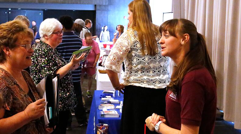 Jordan Kolar, representing the Home Instead company, right, talks to potential employees last year at the Chamber of Greater Springfield and OhioMeansJobs Clark County job fair. Bill Lackey/Staff