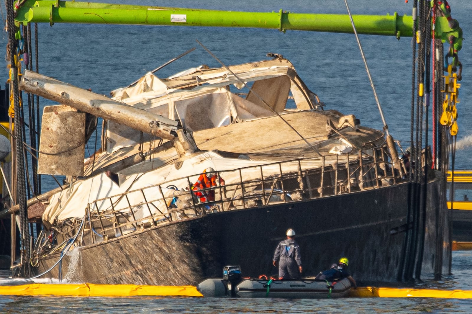 The hull of the superyacht Bayesian, which sank near Palermo, Sicily, on August 19, 2024, is lifted by cranes during salvage operations off the village of Porticello Saturday, June 21, 2025. (AP Photo/Salvatore Cavalli)