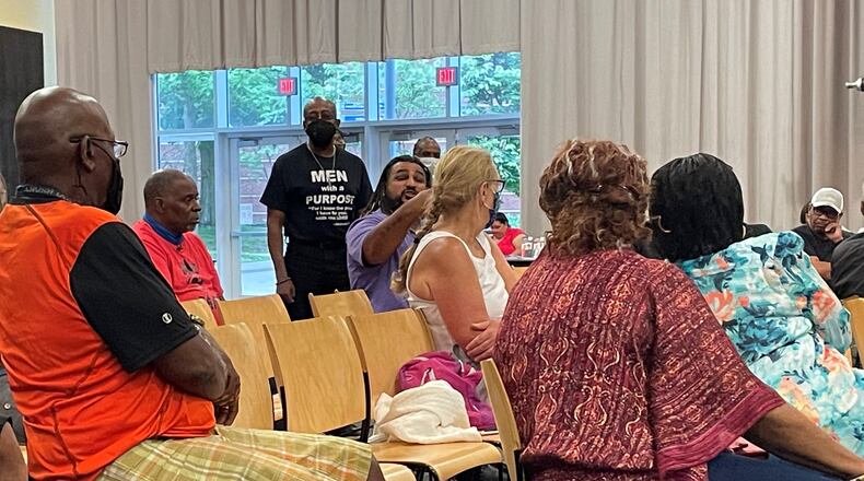 People turn to listen to a man speak about gun violence among young people in the community during Friday's conversation.