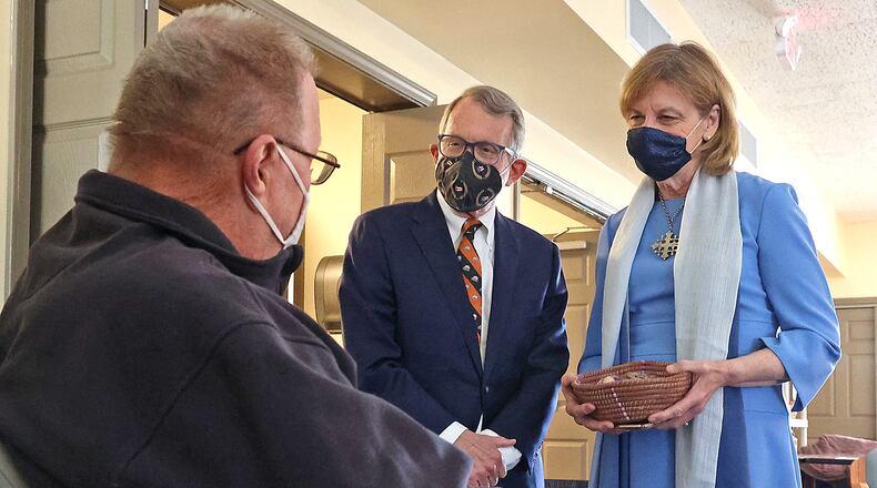 Governor Mike DeWine and his wife, Fran, visit with a man waiting to get his COVID vaccine during the visit to the vaccine clinic at New Carlisle Senior Living. BILL LACKEY/STAFF