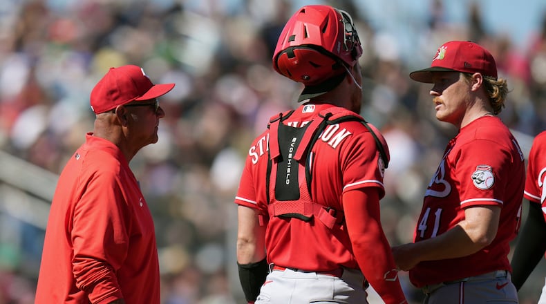 Cincinnati Reds manager Terry Francona, left, arrives at the pitcher's mound to replace Reds starting pitcher Andrew Abbott (41) as Reds catcher Tyler Stephenson looks on during the third inning of a spring training baseball game Friday, March 6, 2026, in Scottsdale, Ariz. (AP Photo/Ross D. Franklin)