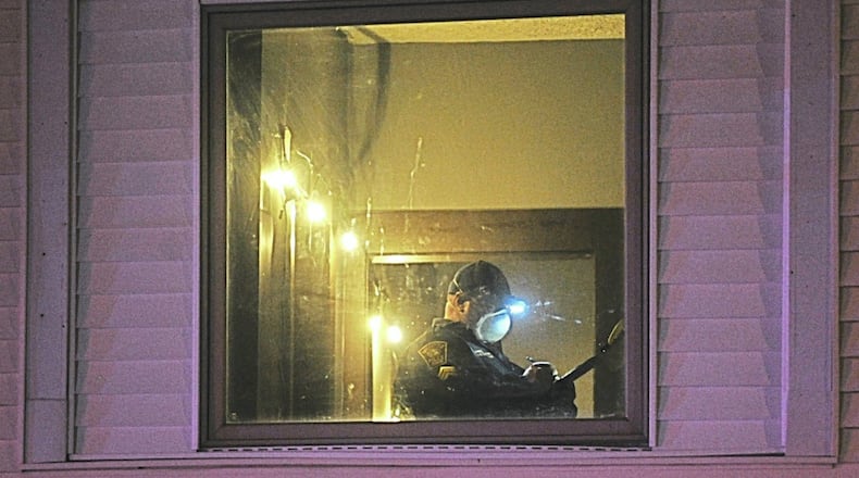 A member of Springfield Police Division investigates the scene of a double fatal shooting on the 900 block of Clinton Ave. late Monday. MARSHALL GORBYSTAFF
