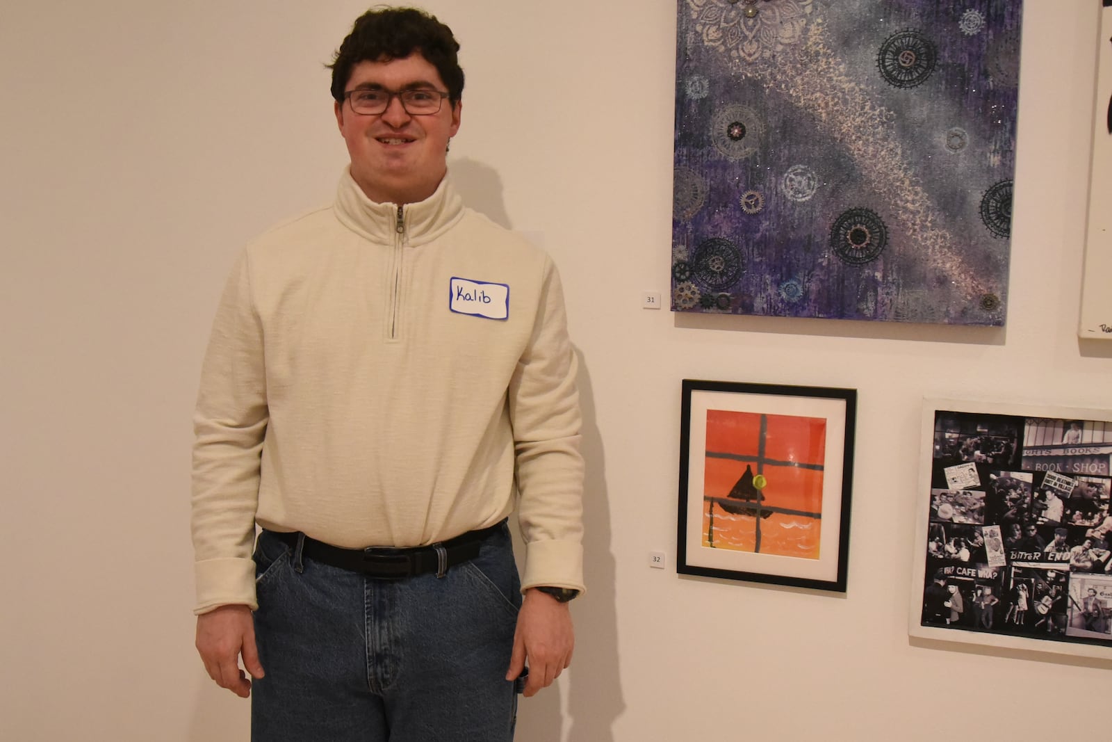 Kaleb Strines smiles while posing next to his painting, located closest to the bottom of the picture, at the Springfield Museum of Art’s McGregor Gallery as part of the museum's 79th Juried Members’ Exhibition during a showcase on Nov. 6, 2025. CONTRIBUTED