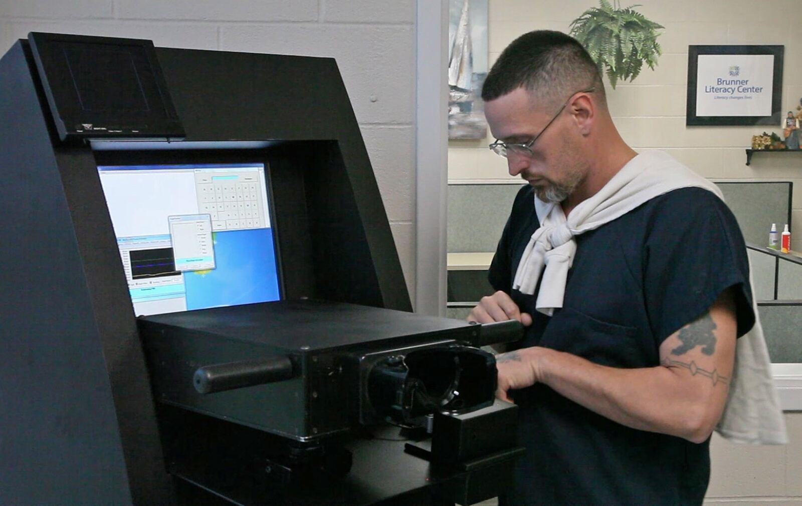 Matt, Bays, 39, from Miamisburg, left, logs in for drug testing by an ocular drug testing machine at Montgomery County Common Pleas Court Adult Probation Day Reporting facility. The machine reads capillaries in the back of the eyes to determine if clients have been using drugs. TY GREENLEES / STAFF