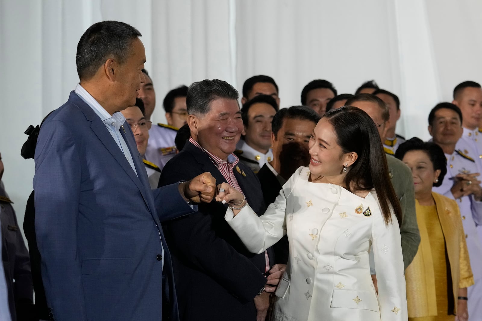 FILE - Thailand's former Prime Minister Srettha Thavisin, left, exchanges a fist bump with new Prime Minister Paetongtarn Shinawatra after Paetongtarn received a royal letter of endorsement for the post at the Pheu Thai party headquarters in Bangkok, Thailand on Aug. 18, 2024. (AP Photo/Sakchai Lalit, File)
