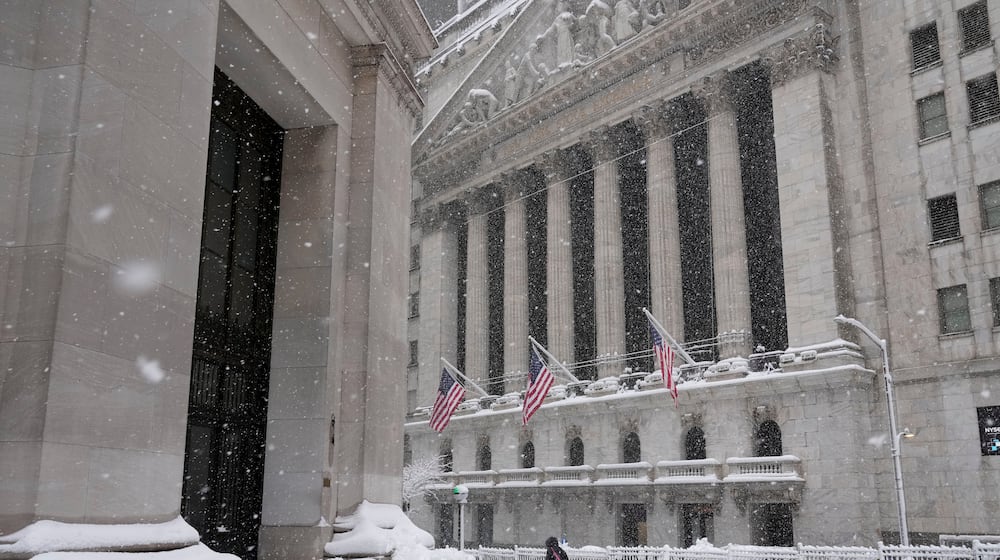 A pedestrian walks outside the New York Stock Exchange during a snow storm, Monday, Feb. 23, 2026, in New York. (AP Photo/Seth Wenig)