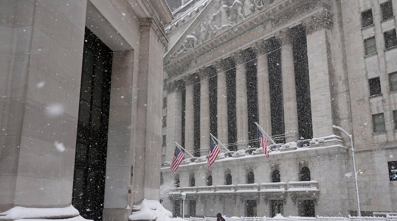 A pedestrian walks outside the New York Stock Exchange during a snow storm, Monday, Feb. 23, 2026, in New York. (AP Photo/Seth Wenig)