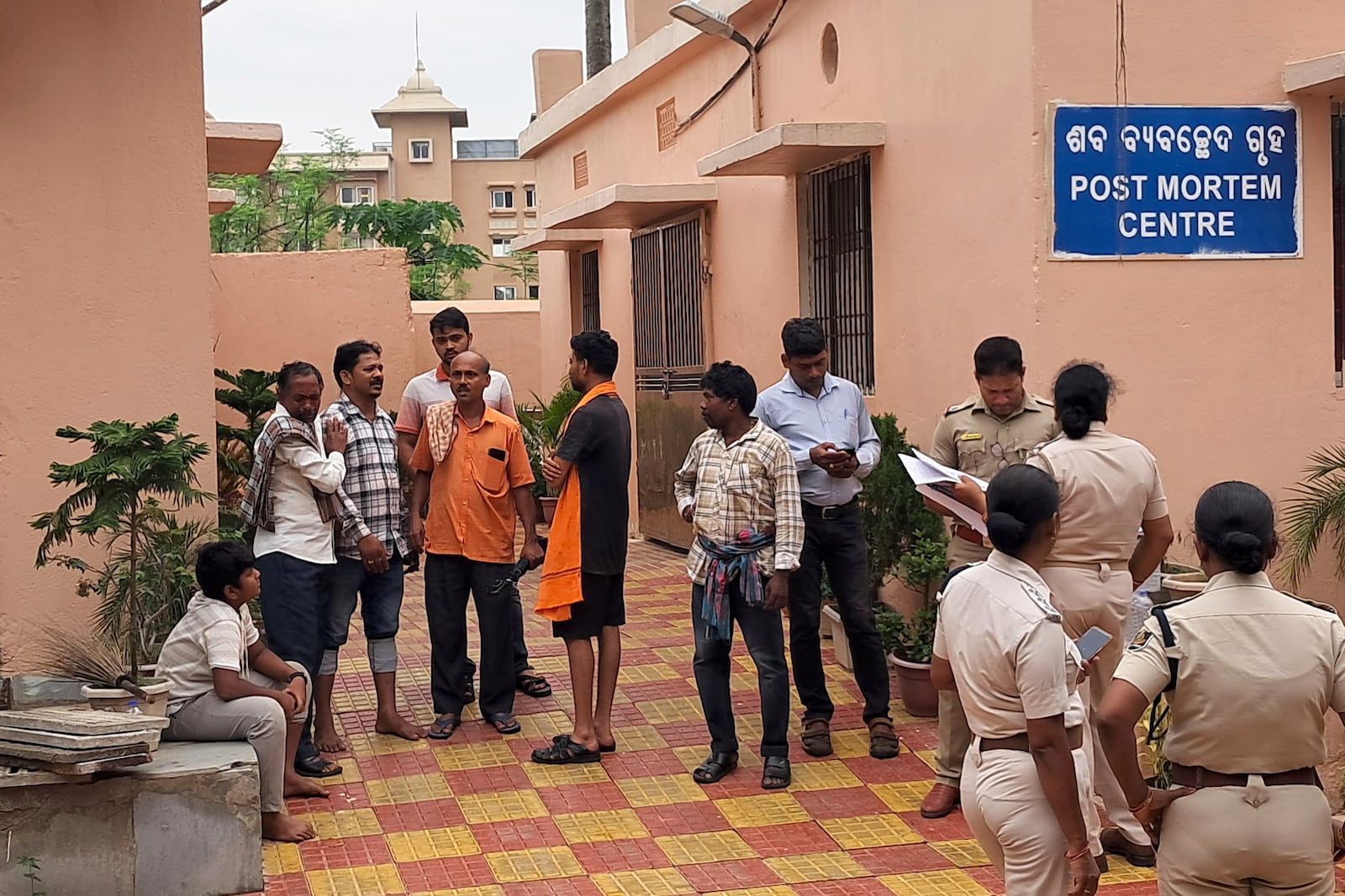 Police personnel and relatives of victims who lost their lives in a crowd surge at a Hindu religious procession wait outside a postmortem center at a government hospital in Puri, India, Sunday, June 29, 2025. (AP Photo)