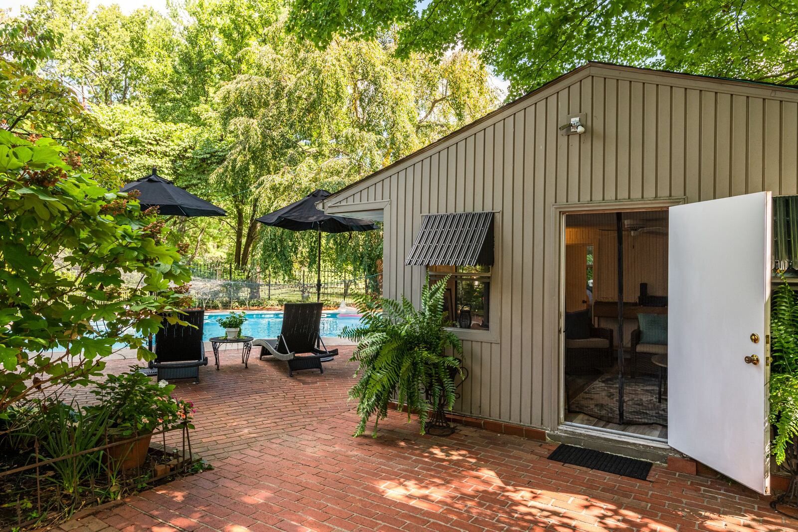 "Within the last four or five years, we have turned a pretty terrible storage building in the back of the house into a comfortable and convenient pool house with sliding barn-type doors that open to the in-ground pool," says Chuck. Contributed