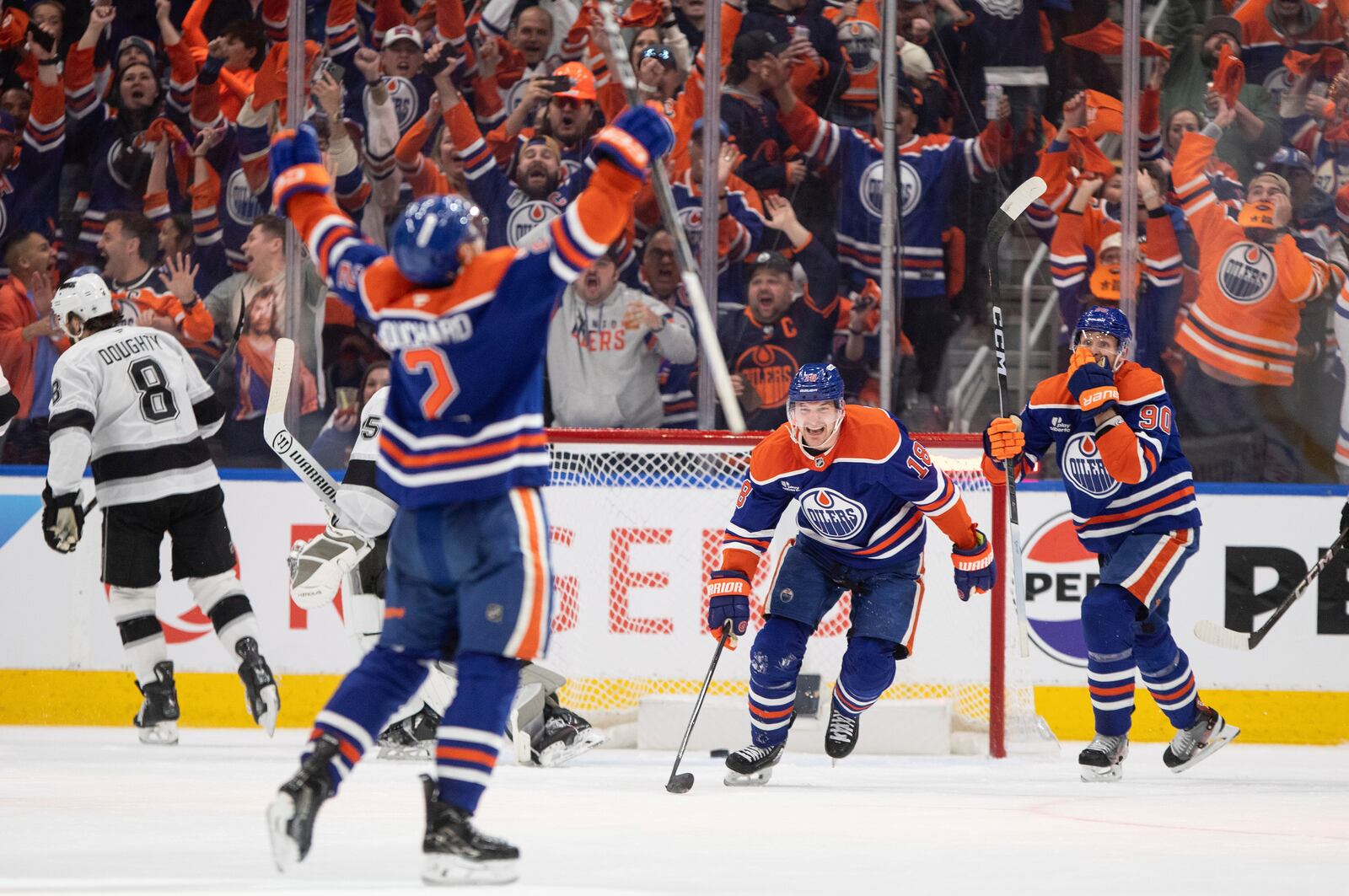 Edmonton Oilers' Evan Bouchard (2), Zach Hyman (18) and Corey Perry (90) celebrate a goal against the Los Angeles Kings during the third period of an NHL playoff game in Edmonton on Sunday, April 27, 2025. (Jason Franson/The Canadian Press via AP)