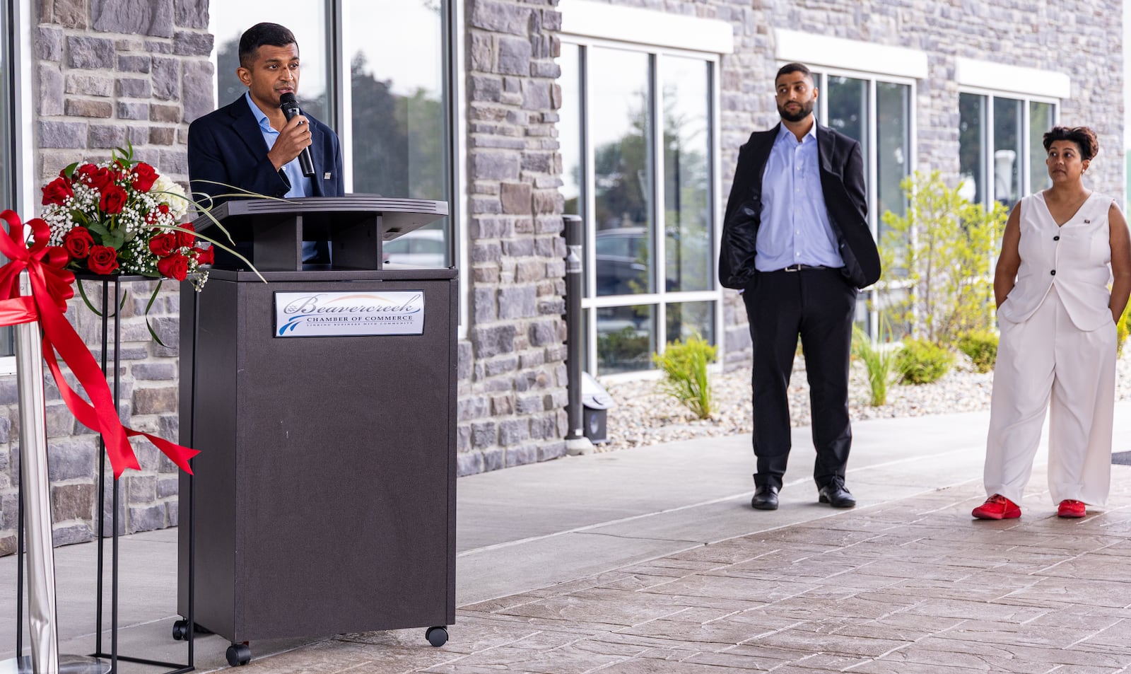 Joshua Patel speaks while family members Roshan and Jasmine Patel listen to celebrate the opening of a hotel that features both Fairfield Inn and Suites and TownePlace Suites next to the Mall at Fairfield Commons on Friday, Sept. 5 in Beavercreek. The family owns and operates Scarlet and Gray Hospitality.  BRYANT BILLING / STAFF