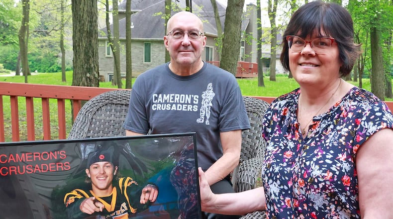Dave and Karen Brucker with a picture of their son, Cameron, Monday, May 8, 2023. Cameron, a Shawnee graduate, died of a drug overdose in 2021. BILL LACKEY/STAFF