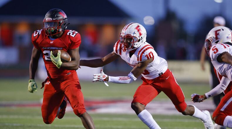 Lakota West running back Cameron Goode tries to elude Fairfield safety Christian Jackson (10) during Friday night's game at West. Nick Graham/STAFF
