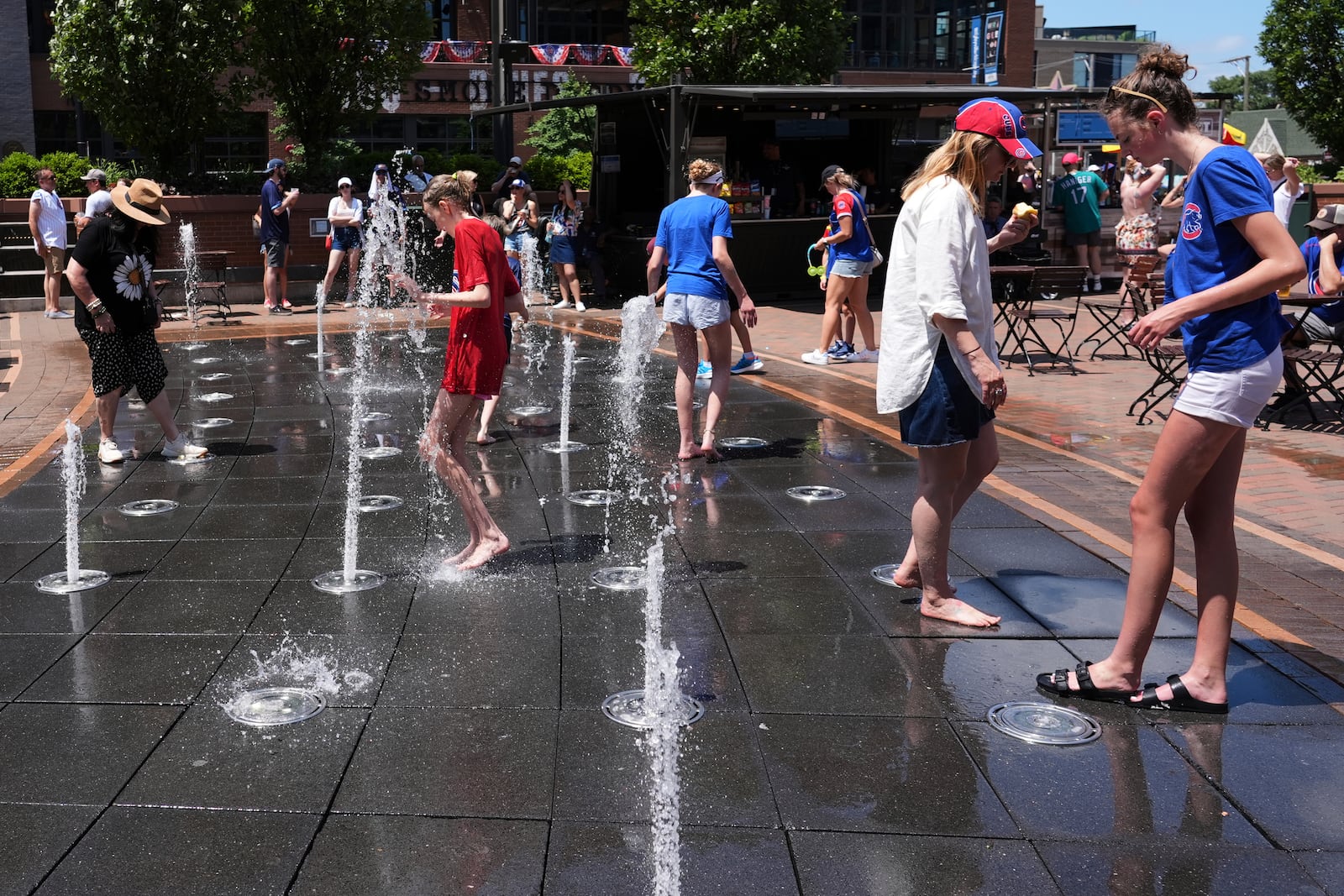 People cool off at a fountain during hot weather in Chicago, Sunday, June 22, 2025. (AP Photo/Nam Y. Huh)