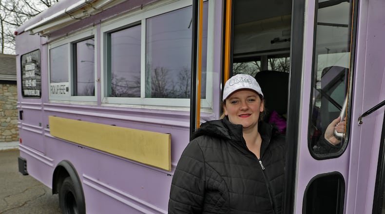 Mandy Gabbert, from Path Integrated Healthcare, in the purple bus they serve free dinners out of for homeless and hungry people. BILL LACKEY/STAFF