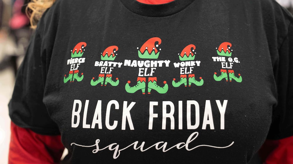 The shirt of a woman who has matching shirts with 4 other friends and all shop together on Black Friday as shoppers browse through Kohl's department store for Black Friday looking for deals, Friday, Nov. 28, 2025, in Woodstock, Ga. (AP Photo/Megan Varner)