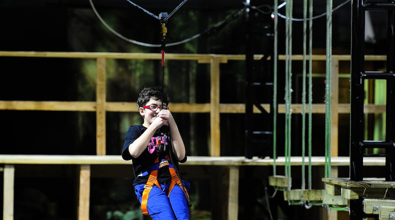 The new exhibit has two sides one is a walk-through, interactive gallery with nine “zones,” each devoted to a different environment or scenario the other is an Adventure Zone Ropes Course and Zip Line, operated by the Air Force Museum Foundation. Eli Mihelcic, age 12 rides the Zip Line Friday Feb. 17, 2023. MARSHALL GORBY\STAFF