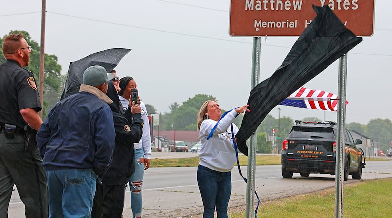 Tracy Yates unveils the sign for the Deputy Sheriff Matthew Yates Memorial Highway Tuesday, June 13, 2023 on U.S. 40 near the intersection with Tuttle Road. A section of the road in eastern Clark County has been renamed in honor of Clark County Deputy, who was killed in the line of duty last year. BILL LACKEY/STAFF